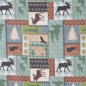 May include: A patchwork fabric with a repeating pattern of woodland creatures and nature scenes. The design features moose, bears, eagles, and trees in a palette of green, brown, and beige. Geometric shapes and decorative borders frame the images, creating a rustic, outdoorsy theme.
