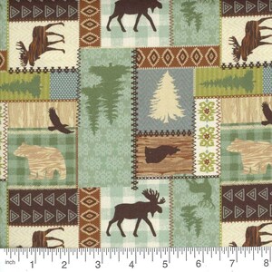 May include: A patchwork fabric featuring woodland animal and tree silhouettes. The design includes moose, bears, eagles, and pine trees in shades of brown, green, and beige. The fabric has a repeating pattern with a ruler at the bottom.