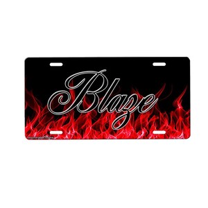 May include: A black and red license plate with the word "Blaze" in a white cursive font on a background of red flames.