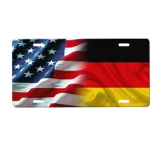 May include: License plate featuring a split design: the American flag on the left and the German flag on the right. The flags are depicted with flowing fabric textures, showcasing the stars and stripes and the black, red, and gold colors.