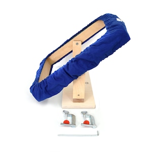 May include: A blue padded wooden frame with a stand and two clamps. The frame is designed for stretching fabric.