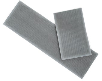May include: Two pieces of gray hook and loop tape. The tape is rectangular and has a textured surface.
