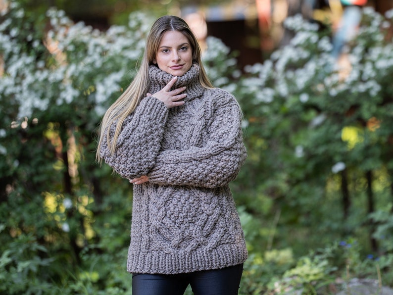 May include: A brown chunky knit turtleneck sweater with a cable knit pattern.
