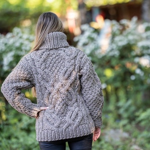 May include: A brown cable knit sweater with a turtleneck.