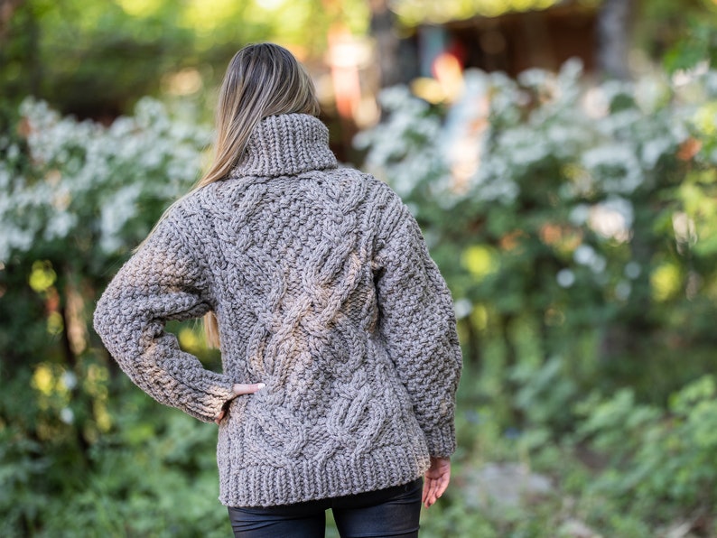 May include: A brown cable knit sweater with a turtleneck.