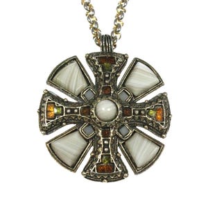 May include: A circular pendant necklace featuring a cross design with a central white stone. The metal frame has an antiqued finish and is inlaid with four white triangular stones and smaller amber-coloured accents on a silver-toned chain.