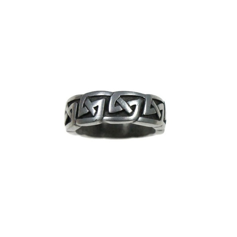 K&ouml;nnte beinhalten: Ein silberfarbener Ring mit einem keltischen Knotenmuster. Der Ring zeigt ein sich wiederholendes Muster aus ineinander verschlungenen Knoten, das ein durchgehendes Band bildet. Der Ring ist vor einem wei&szlig;en Hintergrund platziert.