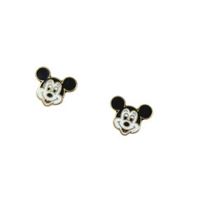 May include: Two small, gold-toned Mickey Mouse face earrings. Each earring features a black head and ears, a white face, and a smiling expression. The earrings are set against a white background.