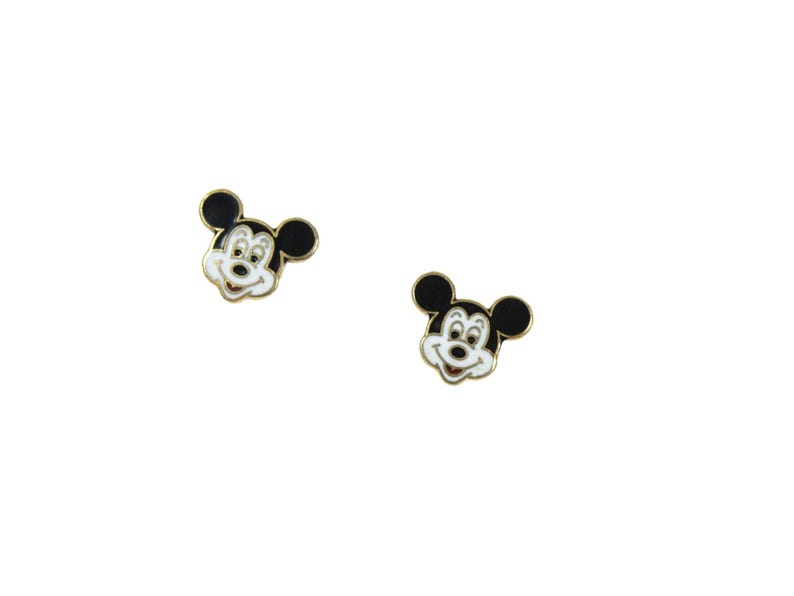 May include: Two small, gold-toned Mickey Mouse face earrings. Each earring features a black head and ears, a white face, and a smiling expression. The earrings are set against a white background.