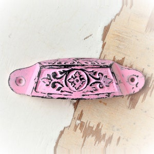 Könnte beinhalten: Rosa Metall-Schubladenzug mit schwarzem Blumendesign. Der Zug hat zwei Löcher zur Montage.