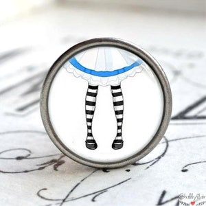 Könnte beinhalten: Ein weißes und blaues Kleid mit schwarz-weißen gestreiften Strümpfen. Das Kleid hat ein blaues Band und einen weißen Spitzenbesatz. Die Strümpfe sind von den Knien abwärts zu sehen.