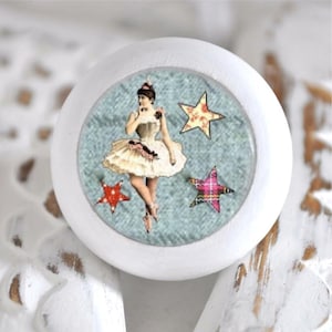 Könnte beinhalten: Weißer runder Knopf mit blauem Hintergrund, auf dem eine Ballerina in einem weißen Tutu und drei bunte Sterne zu sehen sind.