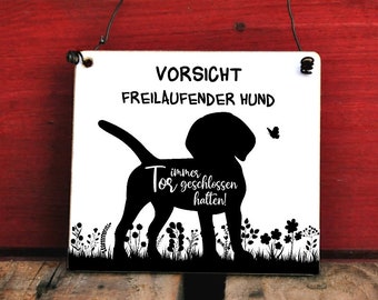 Könnte beinhalten: Ein weißes quadratisches Schild mit schwarzem Text und einer Hundesilhouette. Auf dem Schild steht "VORSICHT FREILAUFENDER HUND" und "Tor immer geschlossen halten!" Ein Schmetterling und ein Blumendesign sind ebenfalls vorhanden.