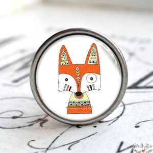 Könnte beinhalten: Ein silberner Knopf mit weißem Hintergrund und einem bunten Comic-Fuchs mit geometrischen Mustern. Der Fuchs ist orange, gelb, blau und grün.