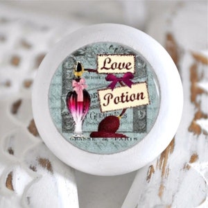 Könnte beinhalten: Weißer runder Knopf mit einem blauen und weißen Muster, das eine Glasflasche mit einer rosa-roten Flüssigkeit und dem Text "Love Potion" zeigt.