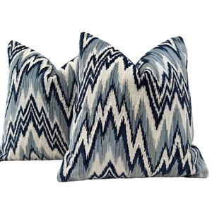 May include: Two blue and white patterned throw pillows with a chevron design.