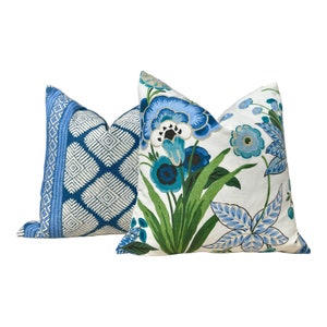 Puede incluir: Dos almohadas decorativas con patrones florales azules y blancos. Una almohada tiene un patr&oacute;n geom&eacute;trico, mientras que la otra tiene un dise&ntilde;o floral m&aacute;s tradicional.