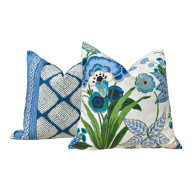 Puede incluir: Dos almohadas decorativas con patrones florales azules y blancos. Una almohada tiene un patr&oacute;n geom&eacute;trico, mientras que la otra tiene un dise&ntilde;o floral m&aacute;s tradicional.