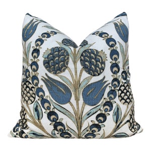 May include: A decorative throw pillow with a blue and white floral pattern. The pillow features a repeating design of stylized flowers and leaves on a white background.