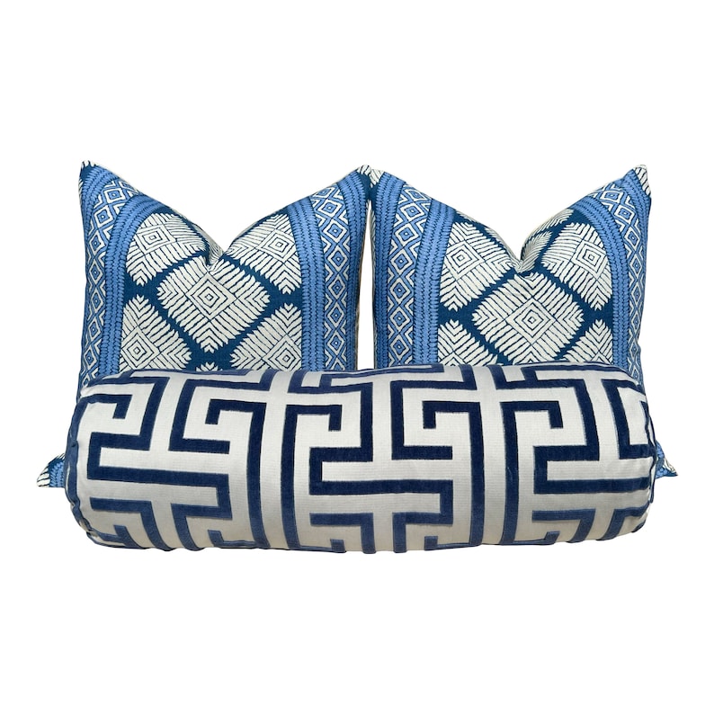 Puede incluir: Un conjunto de tres almohadas decorativas de color azul y blanco, incluyendo una almohada de apoyo con un dise&ntilde;o geom&eacute;trico. Las almohadas presentan un fondo blanco con patrones geom&eacute;tricos azules.