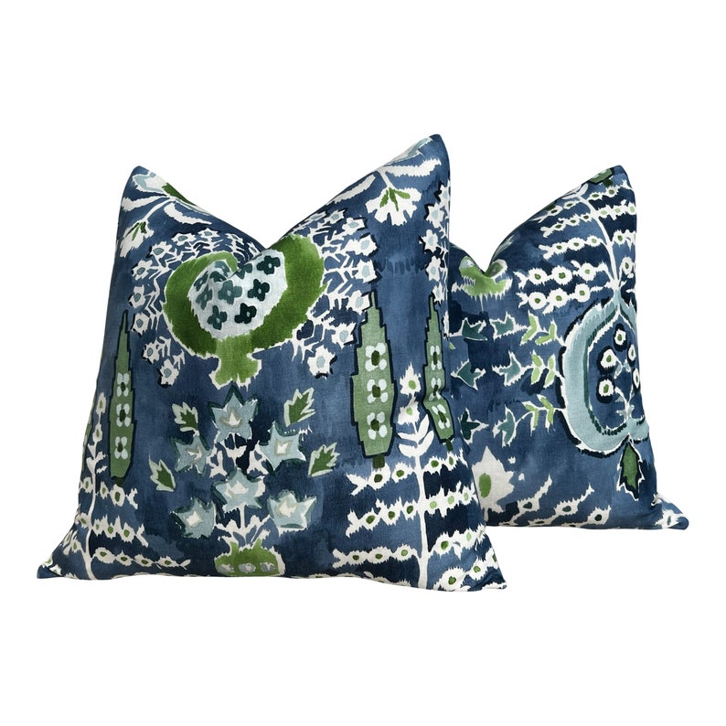 May include: Two blue and green patterned throw pillows with a floral design.