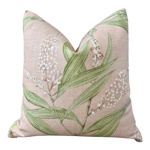 Puede incluir: Una almohada rosa con un patrón floral que presenta hojas verdes y flores blancas con acentos rosados.