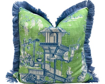 May include: A green and blue patterned throw pillow with a fringe border. The pillow features a traditional Chinese design with a pagoda and figures.
