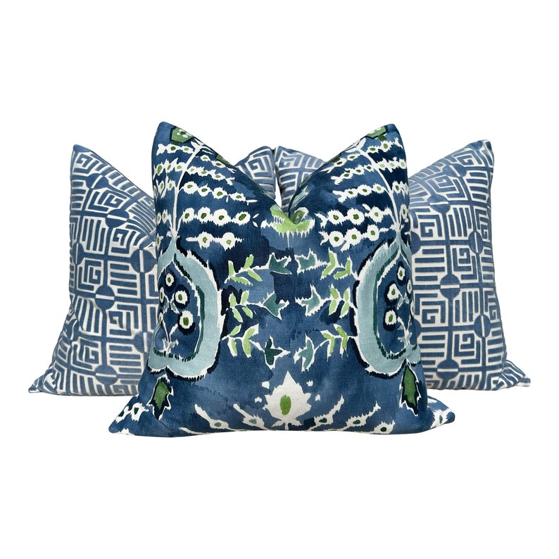 May include: Three decorative throw pillows with blue and green patterns. The center pillow features a floral design with white accents. The two side pillows have a geometric pattern in shades of blue.