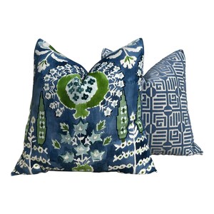 May include: Two decorative throw pillows with a blue and green floral pattern. The larger pillow has a more intricate design with a blue background and green floral accents. The smaller pillow has a geometric pattern with a blue background and white accents.