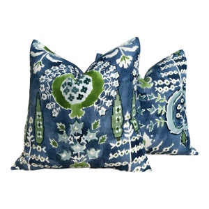 May include: Two blue and green patterned throw pillows with a floral design.