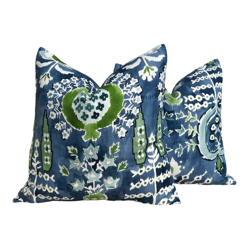 May include: Two blue and green patterned throw pillows with a floral design.