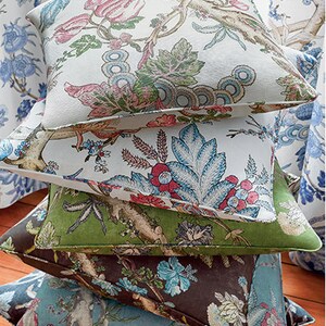 Pu&ograve; includere: Un set di quattro cuscini decorativi con motivi floreali. Il cuscino superiore &egrave; bianco con fiori rosa e blu, il secondo cuscino &egrave; bianco con fiori blu e rossi, il terzo cuscino &egrave; verde con fiori marroni e il cuscino inferiore &egrave; blu con fiori marroni.