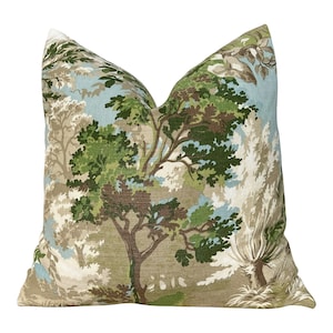 Peut inclure: Un coussin décoratif avec un motif de forêt imprimé sur un tissu beige. Le coussin présente une variété d'arbres et de feuillages verts, bruns et bleus.