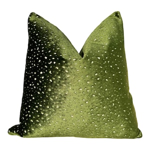 May include: A green velvet pillow with a white polka dot pattern.
