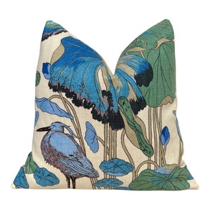 May include: A decorative throw pillow with a blue and green floral pattern featuring a bird and lotus leaves. The pillow has a cream-colored background.