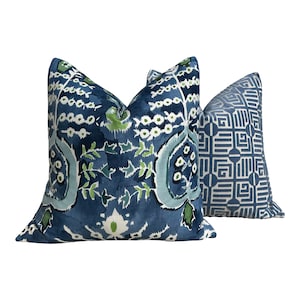 May include: Two decorative throw pillows with blue and green patterns. The larger pillow has a floral design with blue, green, and white accents. The smaller pillow has a geometric pattern with blue and white accents.