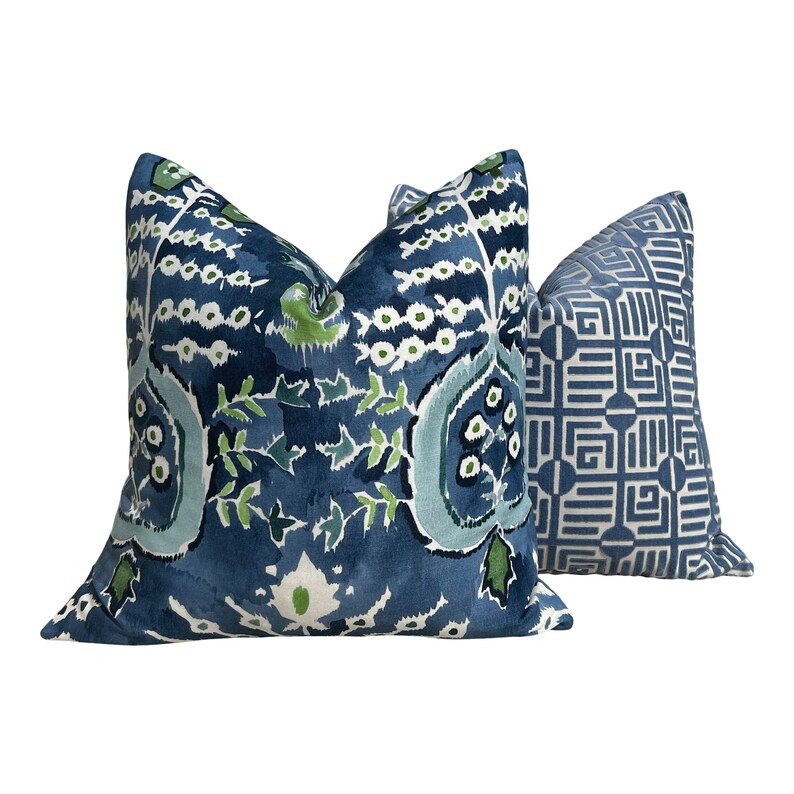 May include: Two decorative throw pillows with blue and green patterns. The larger pillow has a floral design with blue, green, and white accents. The smaller pillow has a geometric pattern with blue and white accents.