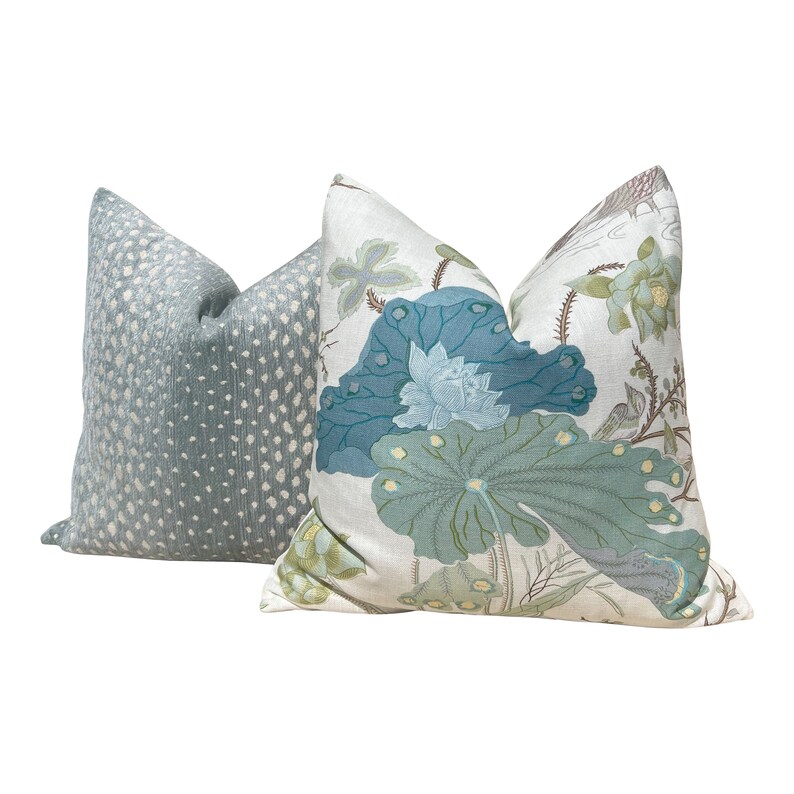 May include: Two decorative throw pillows, one with a blue and green floral pattern and the other with a light blue and white polka dot pattern.