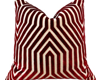 May include: A red and white geometric patterned throw pillow. The pillow has a white background with a red geometric pattern.