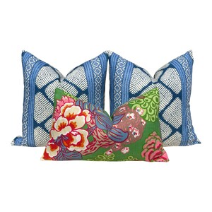 Puede incluir: Tres almohadas decorativas. Dos almohadas son azules y blancas con un patr&oacute;n geom&eacute;trico. Una almohada es verde con un patr&oacute;n floral en tonos de rosa, rojo y azul.