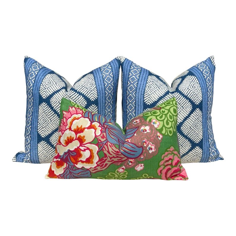 Puede incluir: Tres almohadas decorativas. Dos almohadas son azules y blancas con un patr&oacute;n geom&eacute;trico. Una almohada es verde con un patr&oacute;n floral en tonos de rosa, rojo y azul.