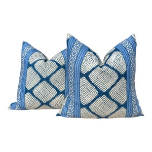 Puede incluir: Dos almohadas de tiro azules y blancas con un dise&ntilde;o geom&eacute;trico. Las almohadas est&aacute;n hechas de una tela suave y tejida y tienen un brillo sutil.