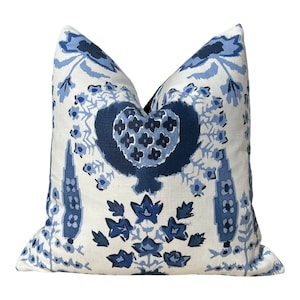 May include: Blue and white patterned throw pillow with a floral design. The pillow has a heart-shaped motif in the center.