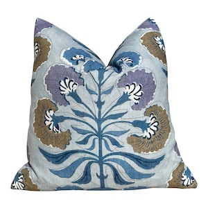May include: A blue and brown floral patterned throw pillow with a light blue background. The pillow features a stylized floral design with blue, brown, and purple flowers.