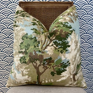 Puede incluir: Una almohada decorativa con un estampado de bosque verde, marr&oacute;n y blanco. La almohada est&aacute; hecha de una tela suave y texturizada y presenta una variedad de &aacute;rboles y follaje.