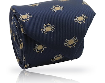 Puede incluir: Corbata enrollada azul marino con un patrón repetido de cangrejos color beige. La corbata está hecha de una tela suave, adecuada para ocasiones formales o informales. El diseño de cangrejo añade un toque náutico al accesorio.