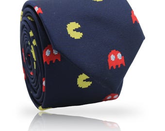 May include: Rolled navy blue necktie featuring a pattern of yellow Pac-Man characters and red ghosts. The tie is made of a smooth fabric and is suitable for formal or casual wear. A fun accessory for video game enthusiasts.