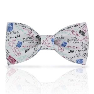 May include: A white bow tie featuring a repeating pattern of mathematical equations, calculators, and geometric shapes in red, blue, and black. A classic accessory for formal or semi-formal wear.