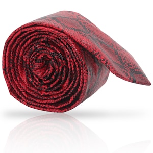 May include: A red and black patterned tie with a snakeskin design. The tie is rolled up and tied in a knot.