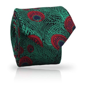 Puede incluir: Una corbata enrollada con un diseño de plumas de pavo real. La corbata presenta un patrón de verde, rojo y azul marino sobre un fondo negro. La corbata está hecha de tela tejida y se muestra sobre un fondo blanco.